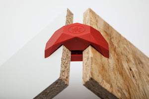 Roter PlayWood 90° Steckverbinder der zwei Holzplatten verbindet.