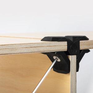 Schwarzer T Verbinder von PlayWood der mit Sechskantschlüssel an Holzplatten befestigt wird.