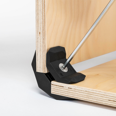 Montageansicht eines 90 Grad Steckverbinders in schwarz von PlayWood mithilfe eines Sechskantschlüssels an zwei Holzplatten.
