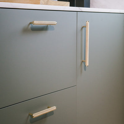 Messing Möbelgriffe in kurzer und langer Ausführung an grünen Küchenunterschrank angebracht.